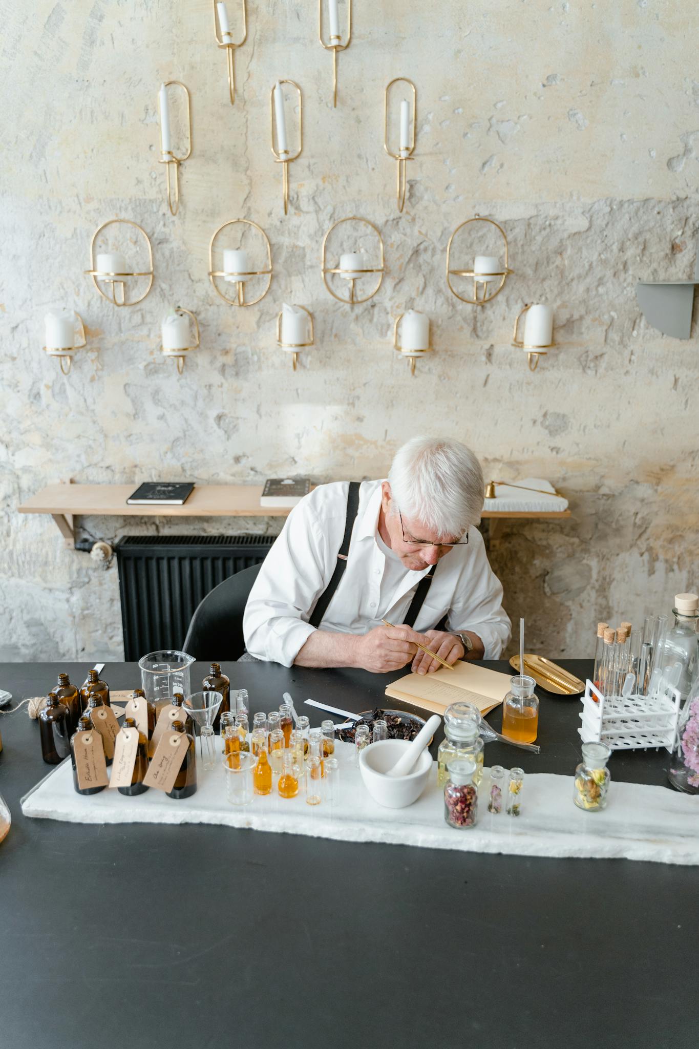 A senior craftsman mixing natural scents in a stylish workshop, showcasing fragrance creation.